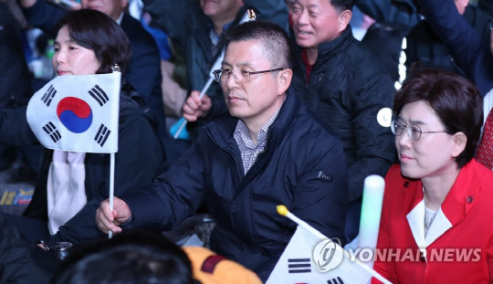 자유한국당 황교안 대표와 전희경(왼쪽)·최연혜(오른쪽) 의원이 25일 오후 서울 광화문광장에서 문재인하야범국민투쟁본부 주최로 열린 제3차 범국민투쟁대회에 참가해 태극기를 흔들고 있다. (사진=연합뉴스)